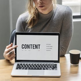 Blond woman pointing at a laptop screen